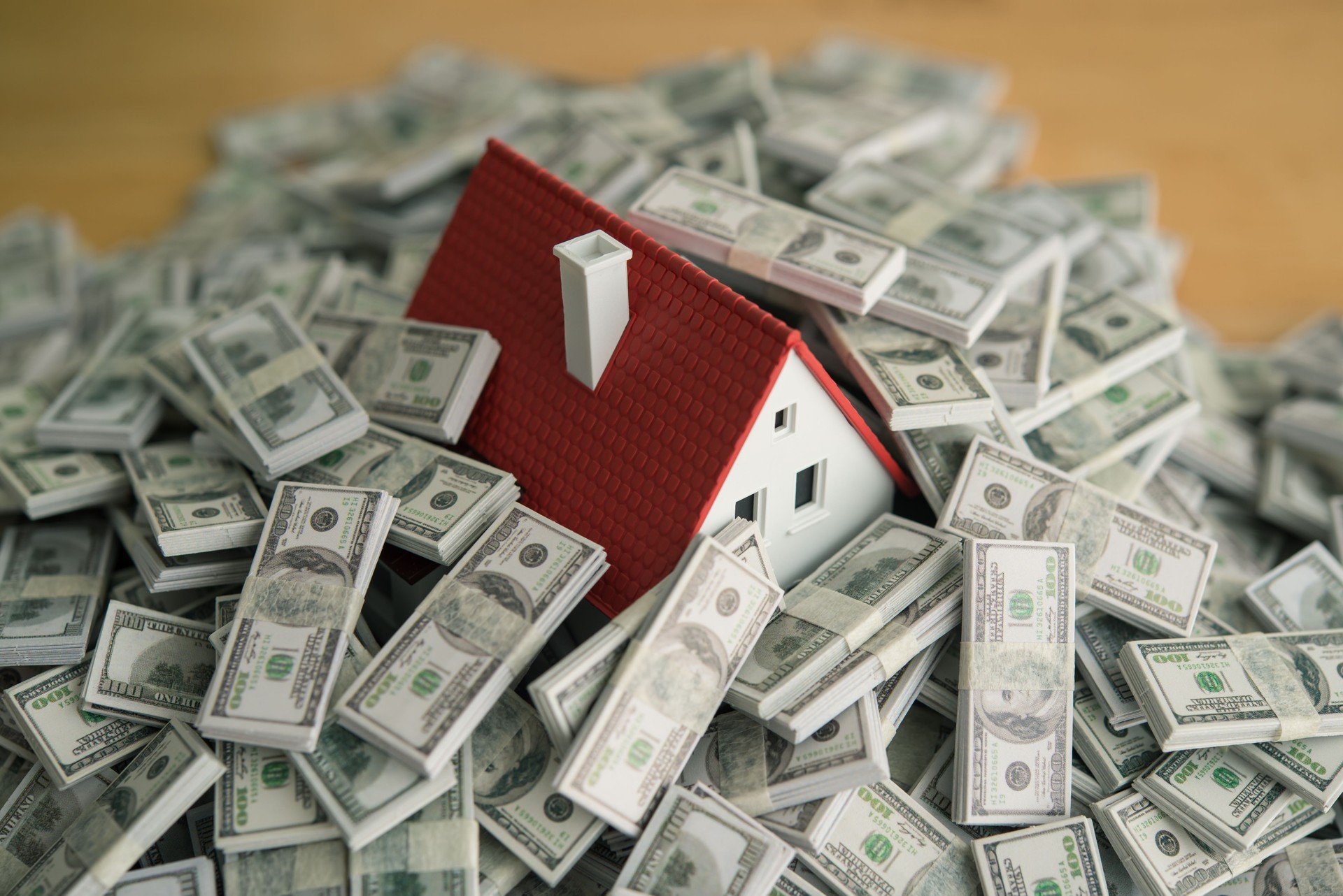 A house drowning in heap US dollar banknotes.