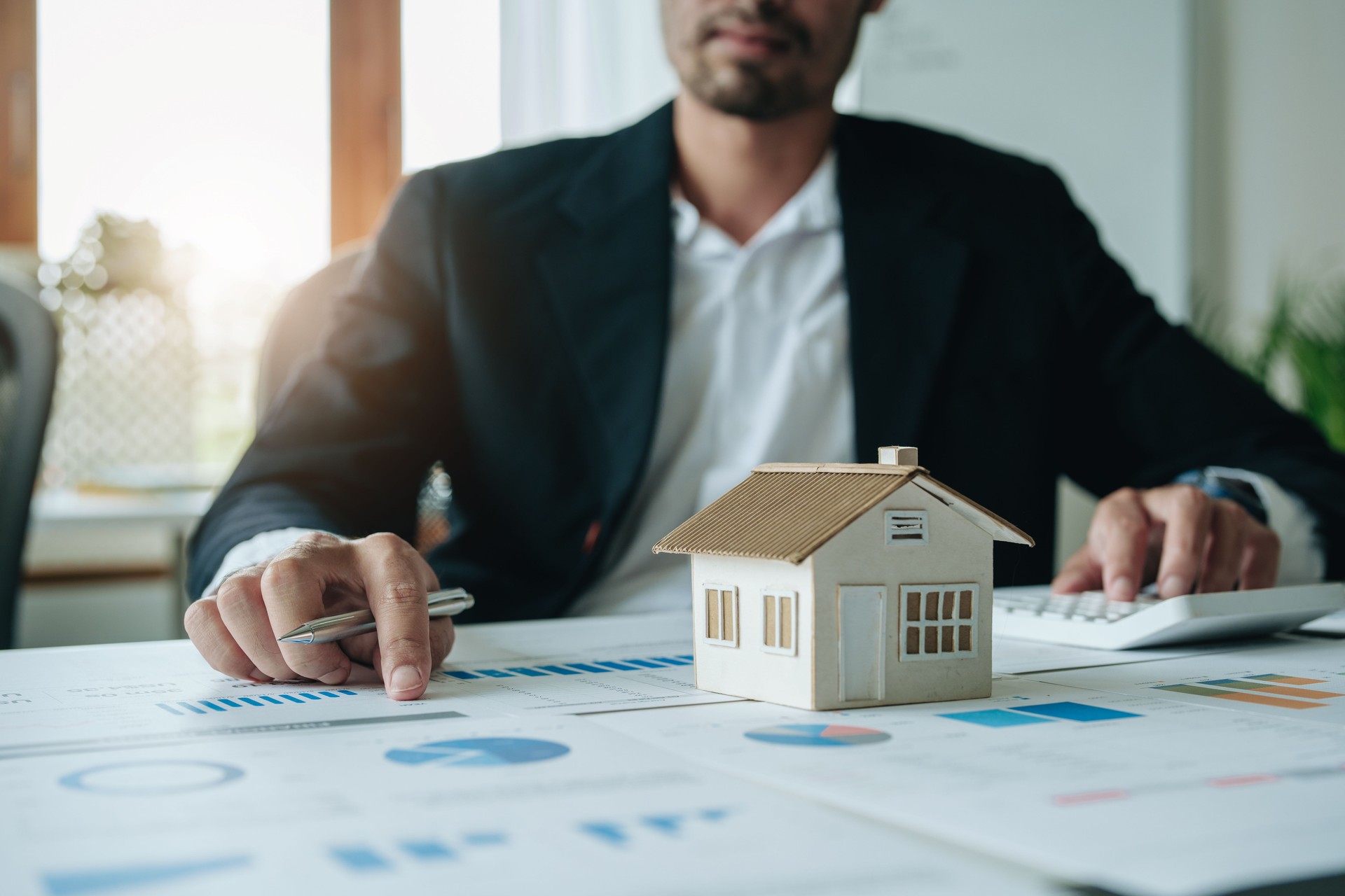 Bank loan workers are using calculators to calculate home loan interest rates for customers to assess their investment capabilities using key documents at working